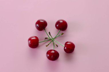 Pembe arka planda olgun kirazlar. Pop Sanat.