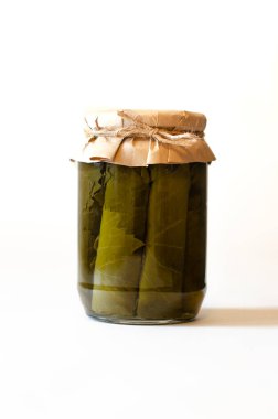 Dolma beyaz arka planda, izole. Kavanozda konserve dolma yaprakları. Depolama, hasat, yarı bitmiş ürünler. Yakın plan..
