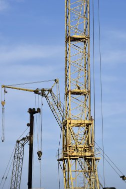 Mavi gökyüzüne karşı vinç ve inşaat alanı