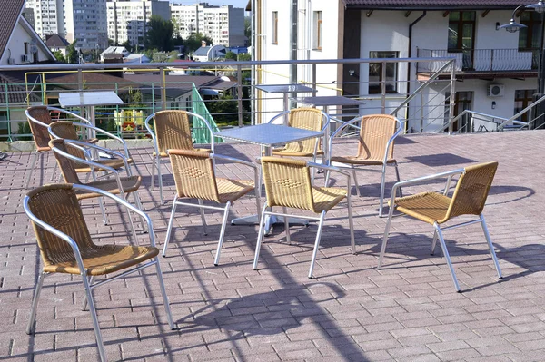 Sillas de mimbre con patas de metal y bastidores están en una zona de cafetería abierta — Foto de Stock