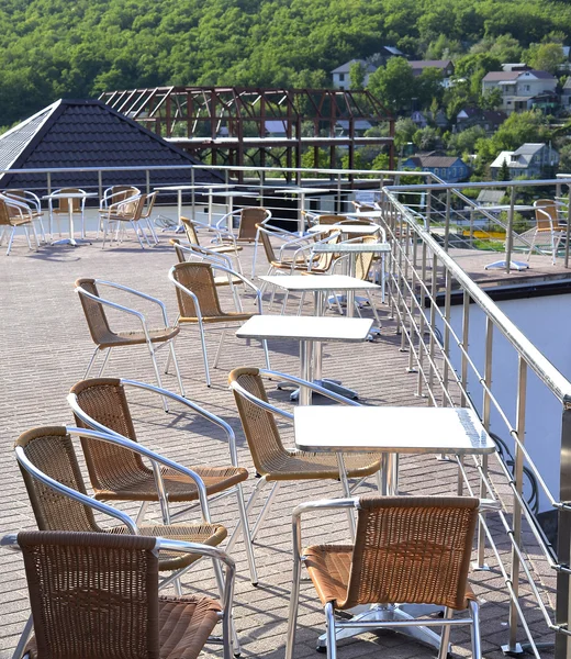 Wicker chairs with metal legs and racks are in an open cafe area — Stock Photo, Image