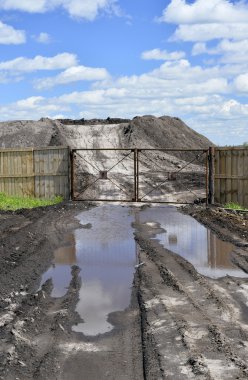 Toprak yol, bir havuz ve bir çok açık hava yer kapalı bir çit için depolanan
