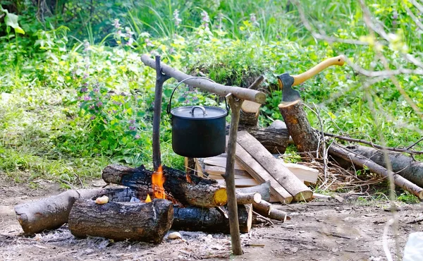 Tourist pot of water hanging over a fire of wood in the Camping — Stock Photo, Image