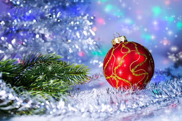 Red Christmas ball and tree branch on the background lights garl Stock Image