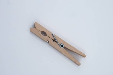 Minimalist düz bir zemin üzerine yerleştirilmiş iki tahta mandalın görüntüsü. Kompozisyonda basitlik, günlük nesneler, denge ve işlevsellik vurgulanıyor.