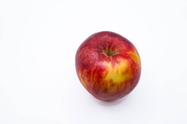 Beyaz arka planda izole edilmiş taze kırmızı ve sarı bir elmanın stüdyo fotoğrafı. Görüntü, sağlıklı yeme, meyve, beslenme, tazelik gibi kavramlar için uygun doğal doku, canlı renk ve fotokopi alanı ile temiz kompozisyon içerir..