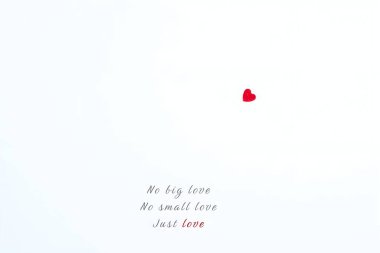 Beyaz arka planda küçük kırmızı bir kalbi olan minimalist bir görüntü ve basit, sakin ve duygusal dengeyi ifade eden ilham verici bir aşk alıntısı..