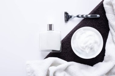 Beyaz ve siyah havlu arka planında kopyalama alanı olan erkek traş aksesuarlarıyla düz konum.