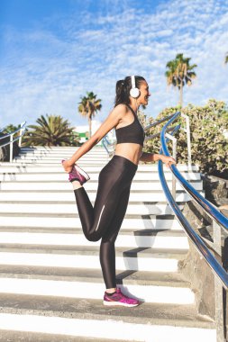 Dışarıda esneyen atletik bir kadın.