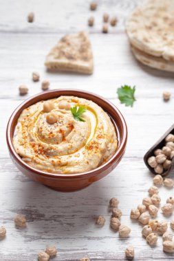 Işık arkaplan dikey formatında ev yapımı humus kasesi.