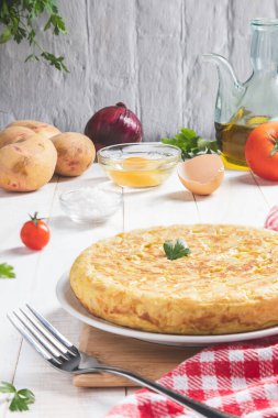 Geleneksel İspanyol omleti. Patatesli ve soğanlı. Hafif kırsal arka planda, dikey formatta. İspanyol tapaları.