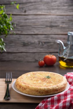 Kırsal arkaplanda geleneksel İspanyol omleti, kopyalama alanı olan dikey biçim.