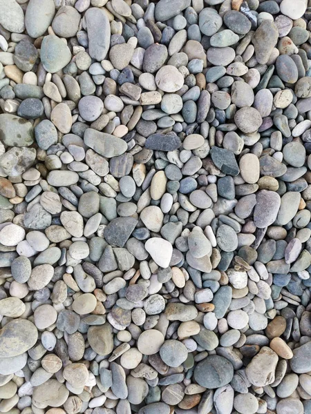 Deniz kenarındaki çok renkli düz taşlar, üst manzara. Soyut arkaplan.