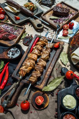 Düz kompozisyon, kızarmış et, şiş kebap, biftek, lula kebap ve sebzeler ahşap masada.