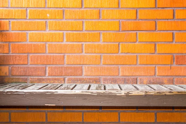 Okd worn bench on a brick wall — Stock Photo, Image