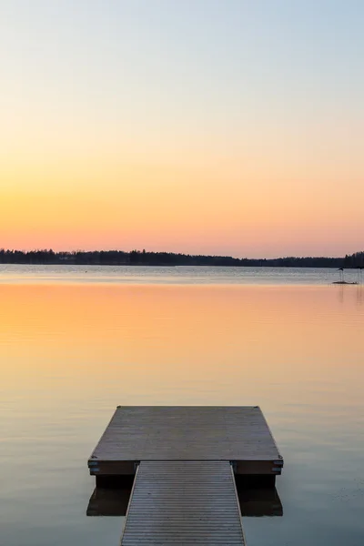 Wooden pier in the calm evening lake portrait — Stock Photo, Image