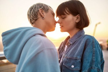 Dışarıda öpüşen iki tutkulu kadına yakın olan genç lezbiyen çift gün doğumunda romantik anlar yaşıyor.