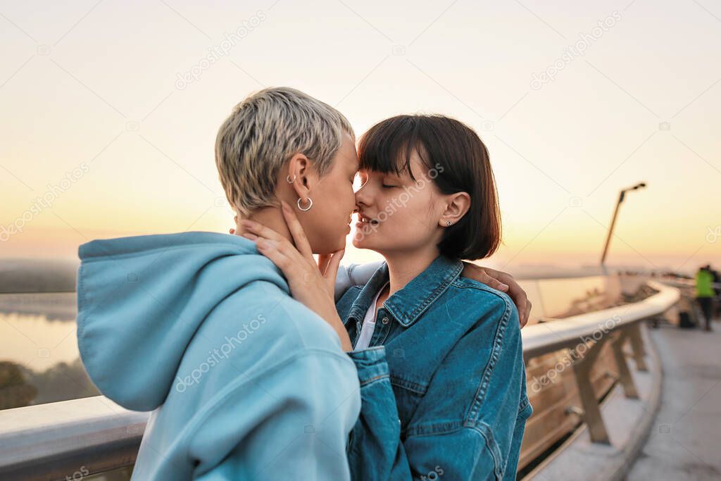 Young passionate lesbian couple going to kiss, Two women enjoying romantic moments together at sunrise