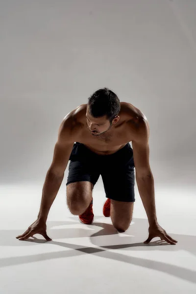 Young handsome caucasian male athlete in low start position — Stock Photo, Image