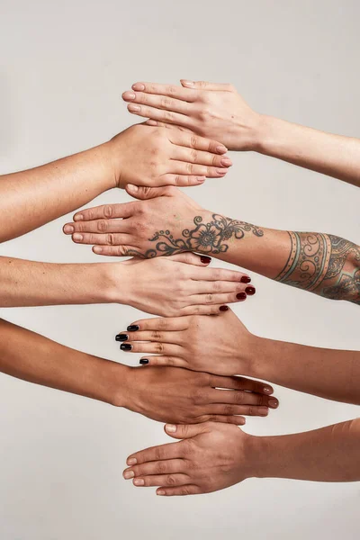 灰色の背景に隔離された列に多様な女性の手を閉じます。社会における人種的団結と関係の概念 — ストック写真
