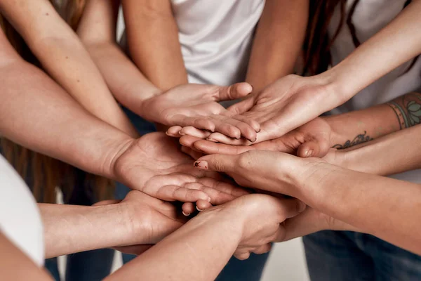 Diversas mujeres sosteniendo sus manos abiertas una encima de la otra como un equipo. Concepto de apoyo, unidad racial y relaciones en la sociedad —  Fotos de Stock