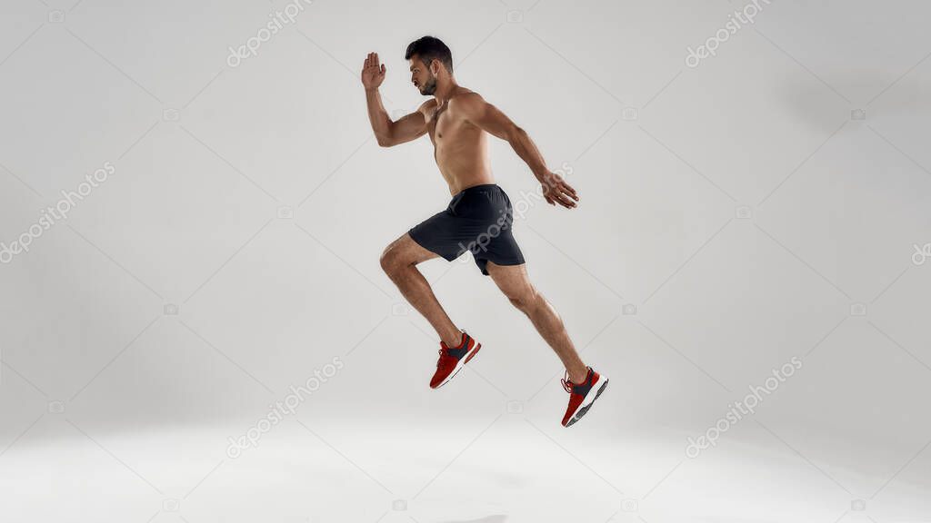 Young handsome caucasian professional male runner jumping