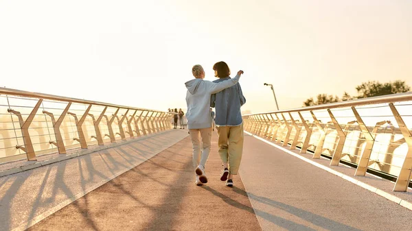 Πλήρες πλάνο λεσβιακών ζευγαριών να αγκαλιάζονται, να περπατάνε στη γέφυρα και να βλέπουν την ανατολή μαζί. — Φωτογραφία Αρχείου