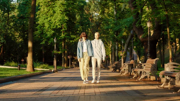 全长拍摄同性恋夫妇有一个日期在城市公园。两个女人在一起，一边在户外散步一边欣赏阳光灿烂的一天 — 图库照片