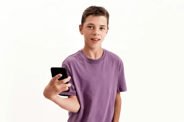 Teenaged disabled boy with cerebral palsy looking at camera and holding smartphone, posing isolated over white background — Stock Photo, Image