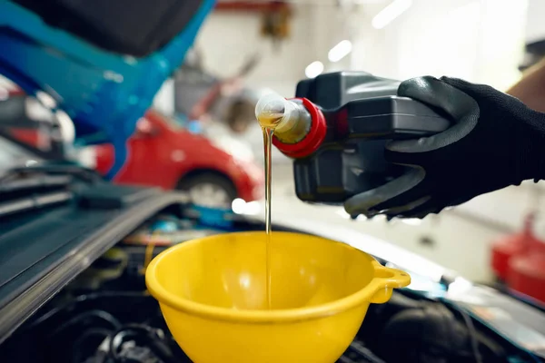 Engine oil from canister pouring in funnel — Stock Image Engine oil from canister pouring in funnel Stock Photo