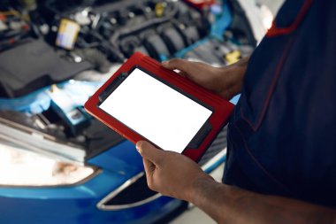 Açık makine kaput arkaplanı üzerindeki boş tablet ekranı