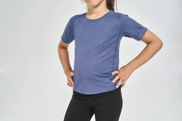 Cropped shot of little sportive girl child in sportswear standing isolated over white background — Stock Photo, Image