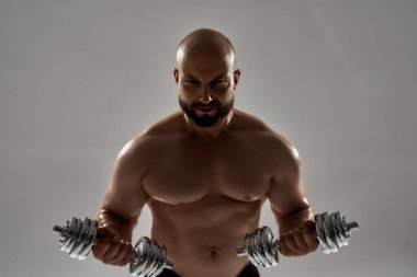 Genç beyaz halterci, halterlerle egzersiz yapıyor.