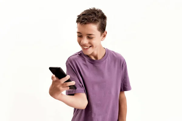 Niño discapacitado adolescente con parálisis cerebral que parece feliz mientras sostiene y usa un teléfono inteligente, posando aislado sobre un fondo blanco — Foto de Stock