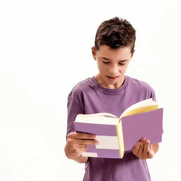 Närbild porträtt av tonåriga funktionshindrade pojke med cerebral pares ser fokuserad medan du läser en bok, stående isolerad över vit bakgrund — Stockfoto