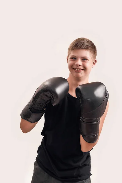 Πορτρέτο του χαρούμενου ανάπηρου αγοριού με σύνδρομο Down φορώντας μεγάλα γάντια πυγμαχίας, χαμογελώντας στην κάμερα ενώ ποζάρει απομονωμένο σε λευκό φόντο — Φωτογραφία Αρχείου