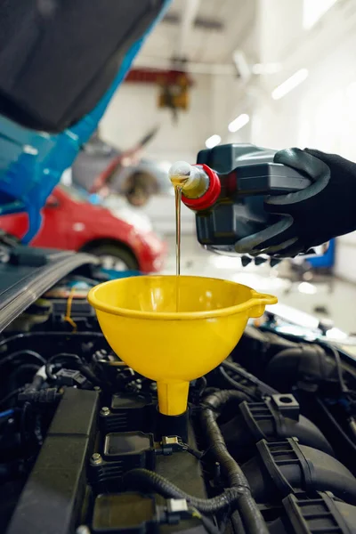 Man pouring engine oil into car motor through funnel — Stock Image Man pouring engine oil into car motor through funnel Royalty Free Stock Images