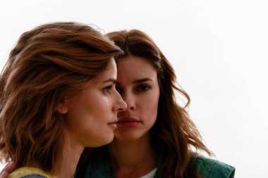 İki çekici genç kızın ön ve yan görünüşü, beyaz arka planda izole edilmiş ikiz kız kardeşler.