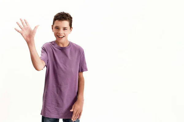 Happy teenaged disabled boy with cerebral palsy smiling and waving at camera, posing isolated over white background — Stock Fotó