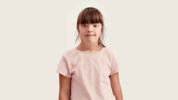 Ritratto di ragazza disabile con sindrome di Down che sorride alla telecamera mentre posa isolata su sfondo bianco — Foto Stock