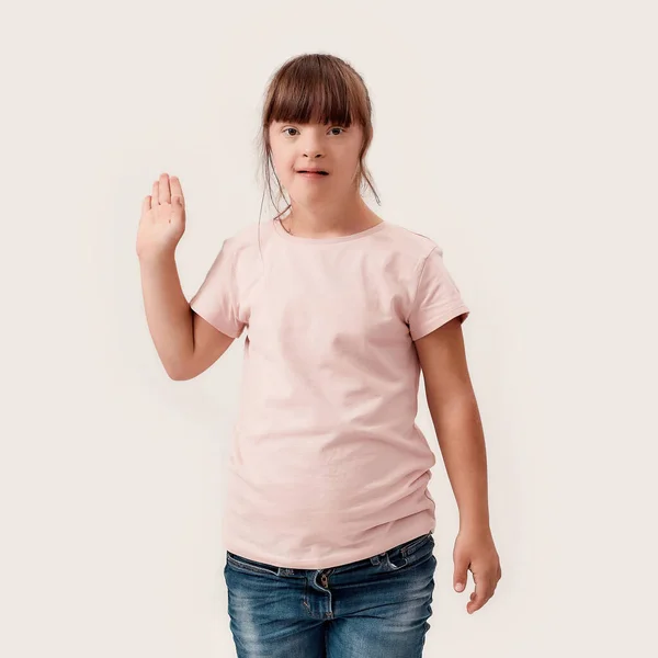 Retrato de chica discapacitada con síndrome de Down sonriendo mientras saludaba a la cámara, de pie aislado sobre fondo blanco —  Fotos de Stock