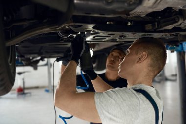 Kafkasyalı tamirci Asyalı çalışanın yanında alt taşakları beceriyor.