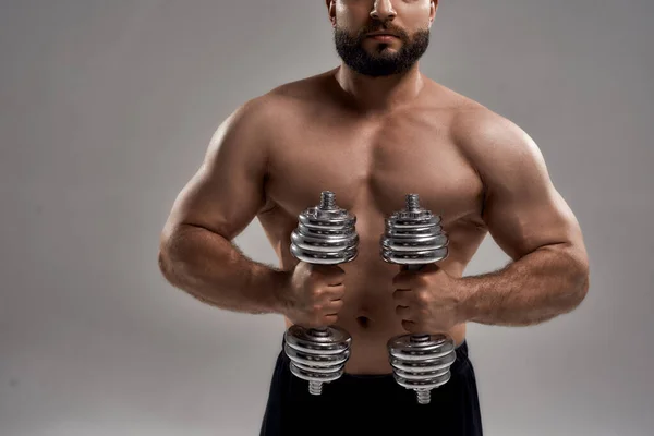 Jovem muscular powerlifter segurando halteres na frente dele — Fotografia de Stock