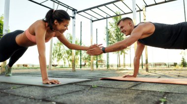 Bir çift genç sporcu el çırpıyor.