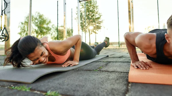 Riendo chica deportiva durante el descanso después del ejercicio de tablón —  Fotos de Stock