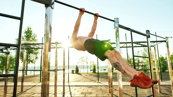 Treinamento de desportista para fazer exercício estático na barra horizontal — Fotografia de Stock