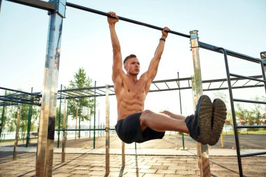 Kaslı gövdeli genç beyaz adam köşe egzersizi yapıyor.