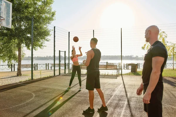Foto panjang orang-orang muda aktif menghabiskan waktu bersama-sama di luar ruangan bermain basket pada hari yang cerah — Stok Foto