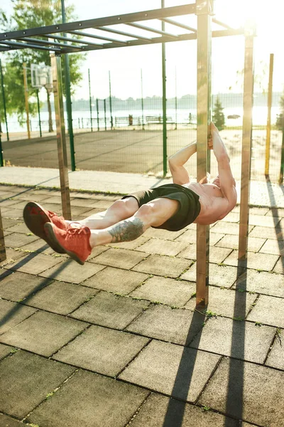 Deportista colgando horizontalmente en el aire durante el entrenamiento —  Fotos de Stock