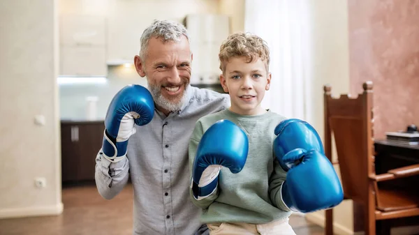 Família desportiva. Retrato de avô feliz e neto vestindo luvas de boxe e sorrindo para a câmera — Fotografia de Stock